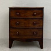 A Georgian mahogany bow-fronted chest of drawers of small size having a thumb-moulded top over three