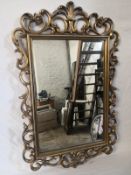 A contemporary Florentine style wall mirror having a rectangular bevelled plate in a scrolling