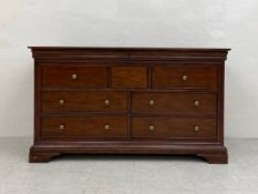 A contemporary Georgian style mahogany sideboard or chest having a moulded cornice over an