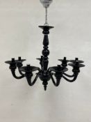 A contemporary black glass chandelier having a baluster form stem with a ball and spire pendant