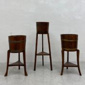 Three early 20th century oak planters or jardinieres each having a brass bound barrel form top
