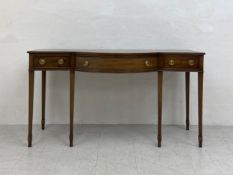 A Regency mahogany sideboard or serving table having a breakfront top over a single bow-fronted