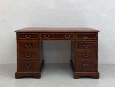 An Edwardian Georgian style twin pedestal desk in three parts having a rectangular top with a tooled
