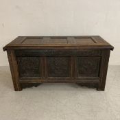 A 17th century carved oak panelled coffer with date and inscription to the frieze raised on stile