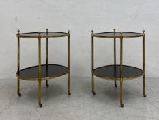A pair of vintage brass framed lamp tables with inset tooled leather tops and undertiers raised on