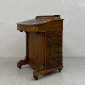 A 19th century walnut Davenport desk having a lidded superstructure with a fitted interior over a