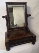 A 19th century mahogany toilet mirror having a rectangular plate in a simple frame raised on a
