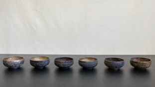 A set of six Indian silver dishes with embossed elephant and tiger decoration in a jungle setting