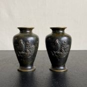 A pair of Japanese bronze vases of baluster form with bird and flowerhead decoration in relief. H.