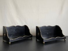 A pair of Regency ebonised and brass desk top bookcases with lion mask handles resting on ball feet.