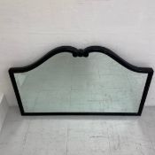 A C.1900 overmantle mirror having a shaped and bevelled plate in a carved black lacquered frame. H.