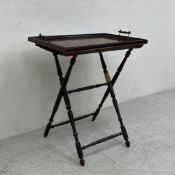 A C.1900 mahogany butlers tray table in two parts having a tray top with gallery surround raised
