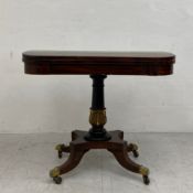 A Regency rosewood card table having a rectangular crossbanded top with curved corners, hinged