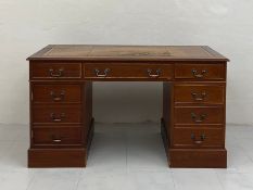 A Georgian style mahogany twin pedestal desk having a tooled and gilt leather top with a moulded