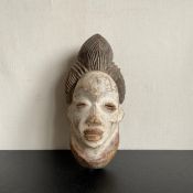 Two painted African masks and a lacquered hinged box in the shape of a clam shell. L.29.5cm