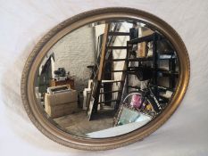 A 20th century gilt mirror in the French 19th century style having a bevelled oval plate in a