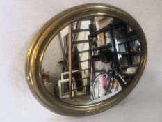 a 20th century wall mirror having an oval plate in a moulded brass frame. 53X42cm