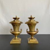 A pair of late 19th century gilt metal campana urn form candlesticks with lift out flame finials.