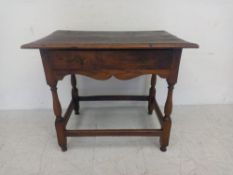 An 18th century oak side table having a thumb-moulded plank top over a single frieze drawer with a