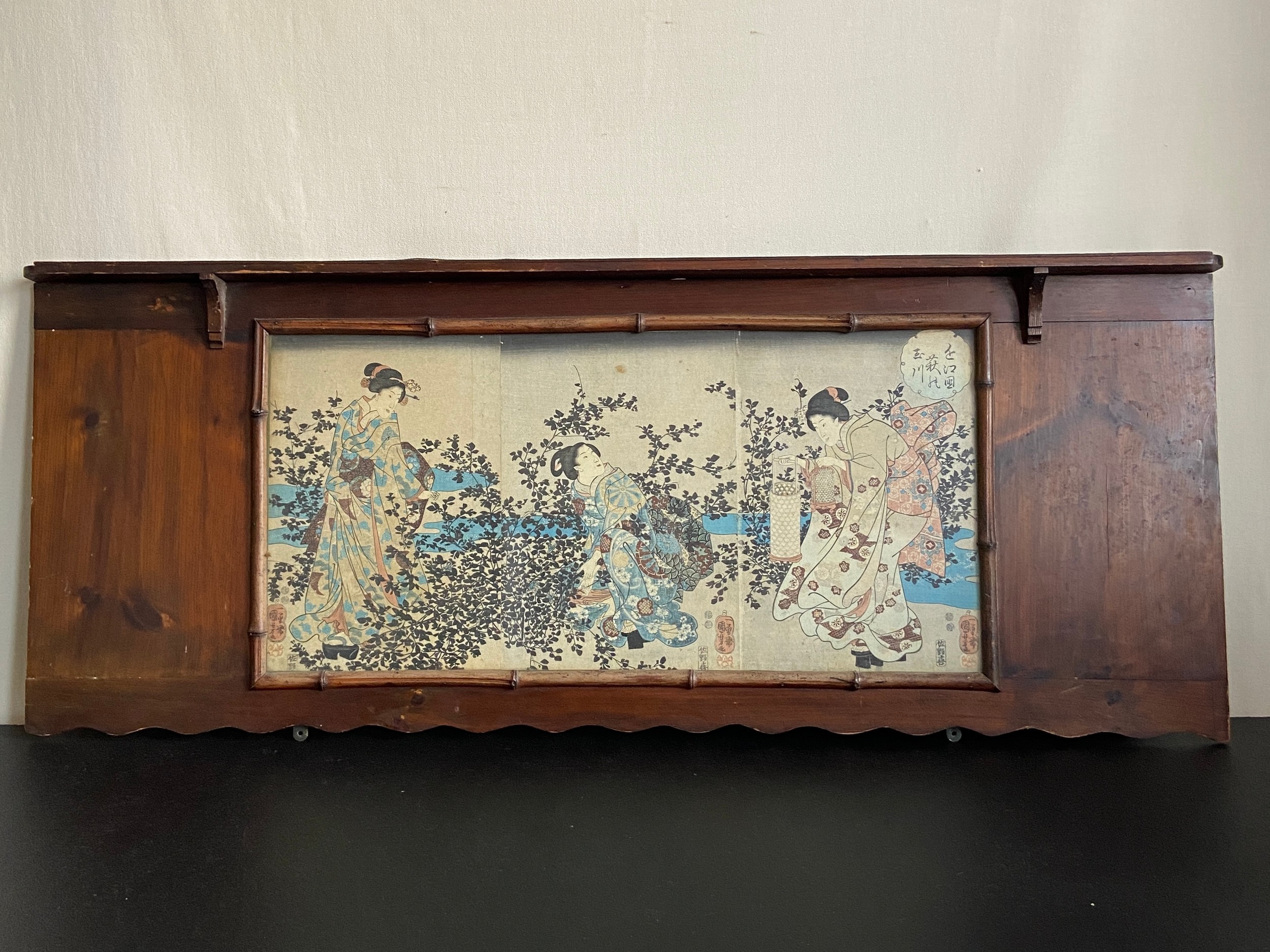 A Japanese ink on paper, figures in a garden in a wide bamboo effect frame, signed. W.120cm