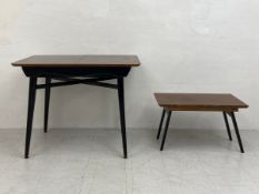 A mid-century metamorphic extending dining table having a rectangular teak top with one additional