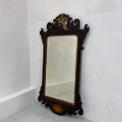 A Georgian mahogany fret mirror having shaped and bevelled plate in a parcel gilt and scrolling