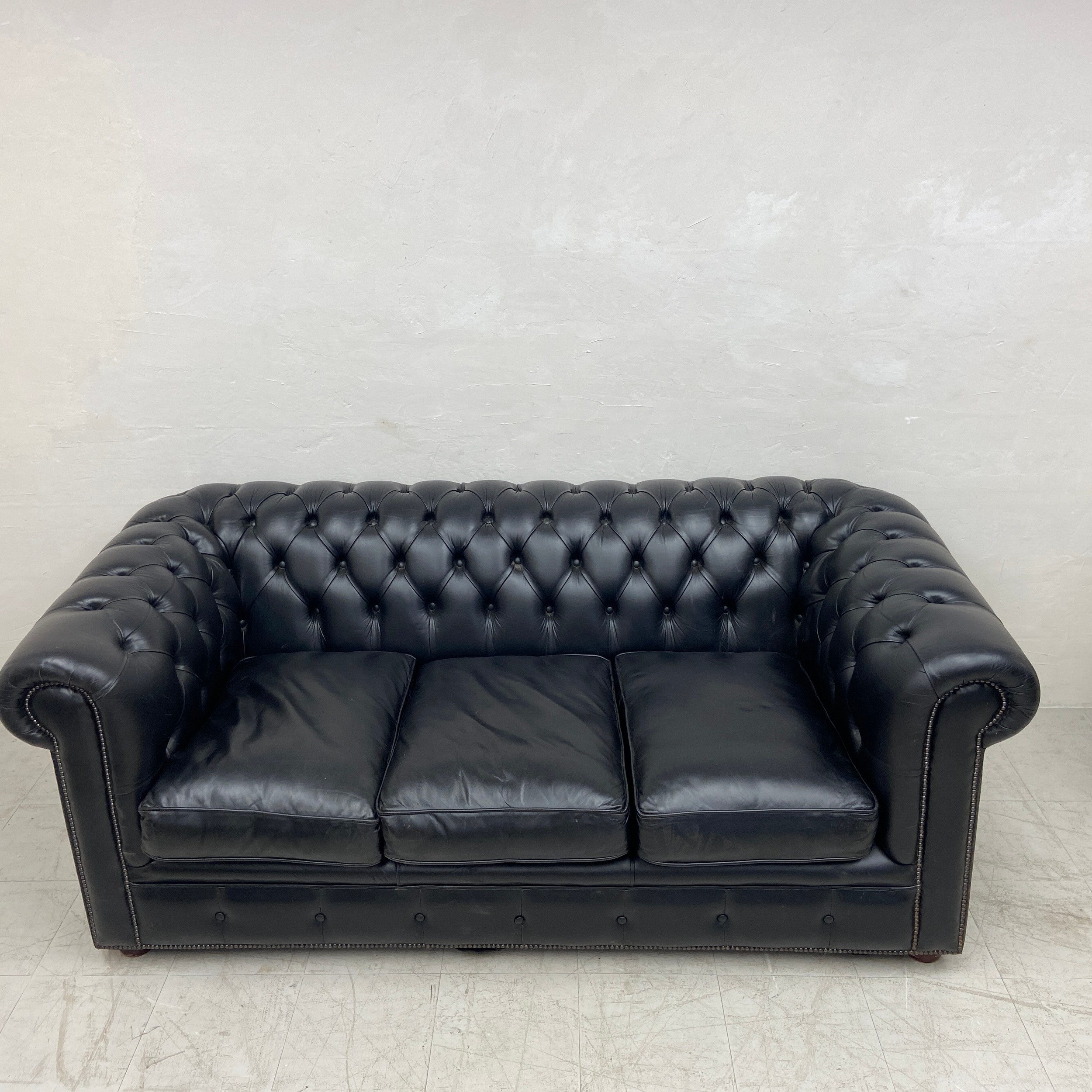A black leather three seater Chesterfield sofa having a scrolled deep button back and arms over a - Image 3 of 4