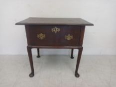 An early 18th century mahogany lowboy or side table having a plank top over a deep frieze drawer