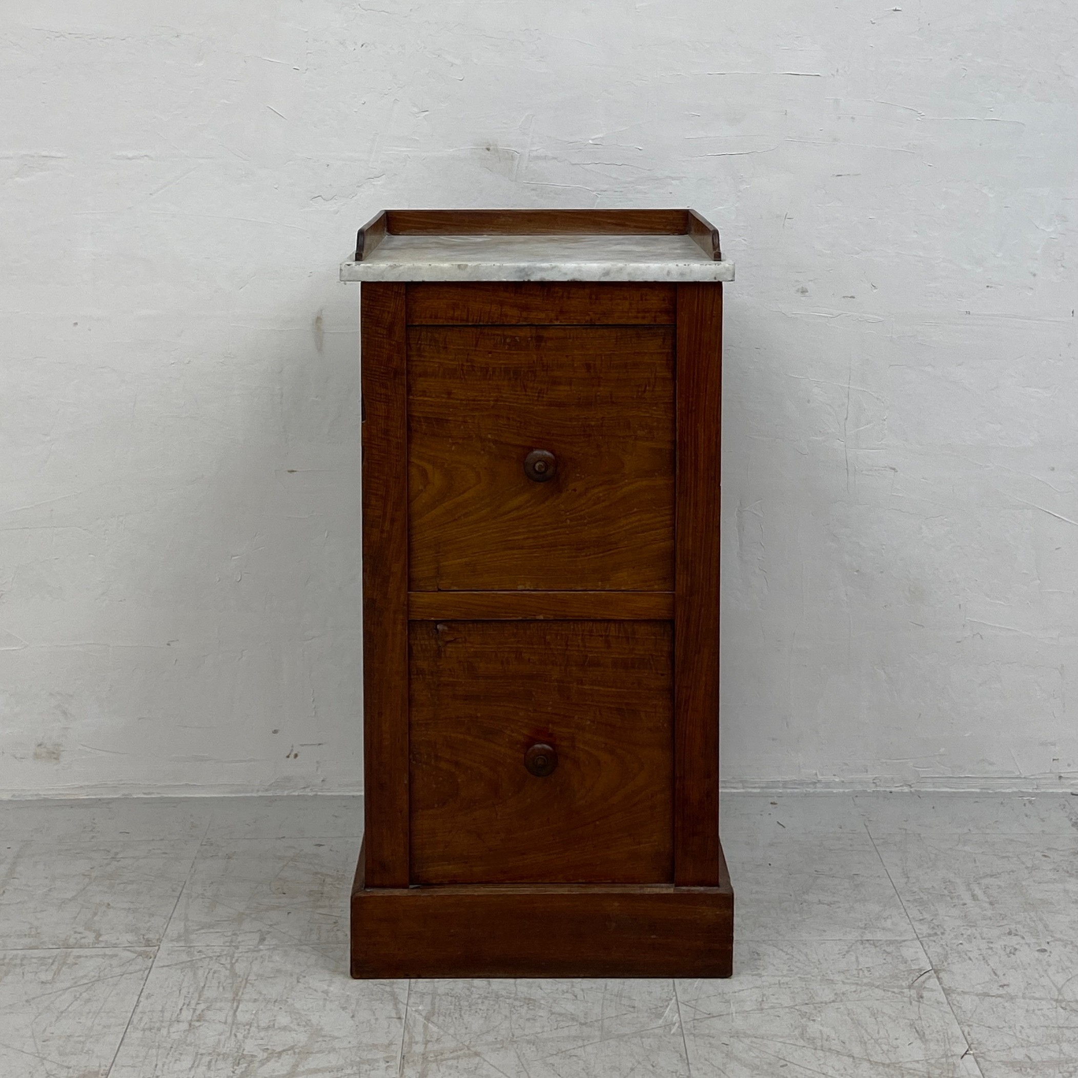 A Louis Philippe flame mahogany bedside cabinet with marble top above a faux twin drawer door