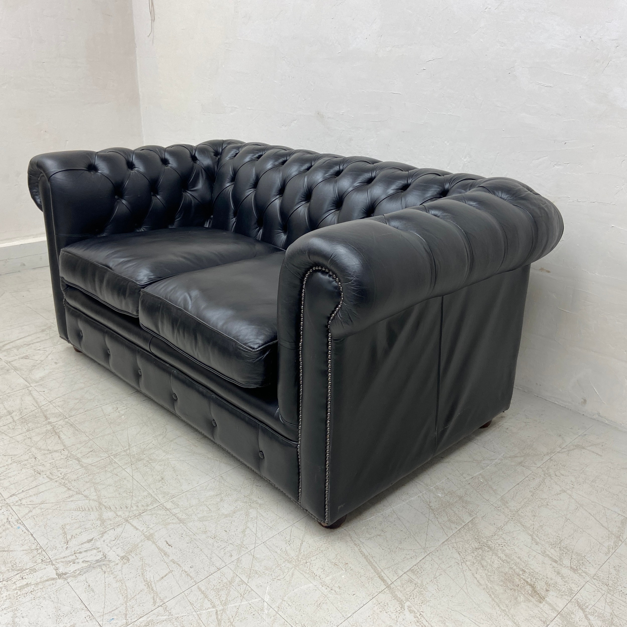 A black leather two seater Chesterfield sofa having a scrolled deep button back and arms over a - Image 2 of 3