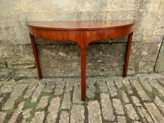 A Georgian mahogany d-end side table having a bowed top over a shaped crossbanded frieze raised on