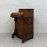 A 19th century burr walnut piano top Davenport having a thumb moulded top hinged to reveal a