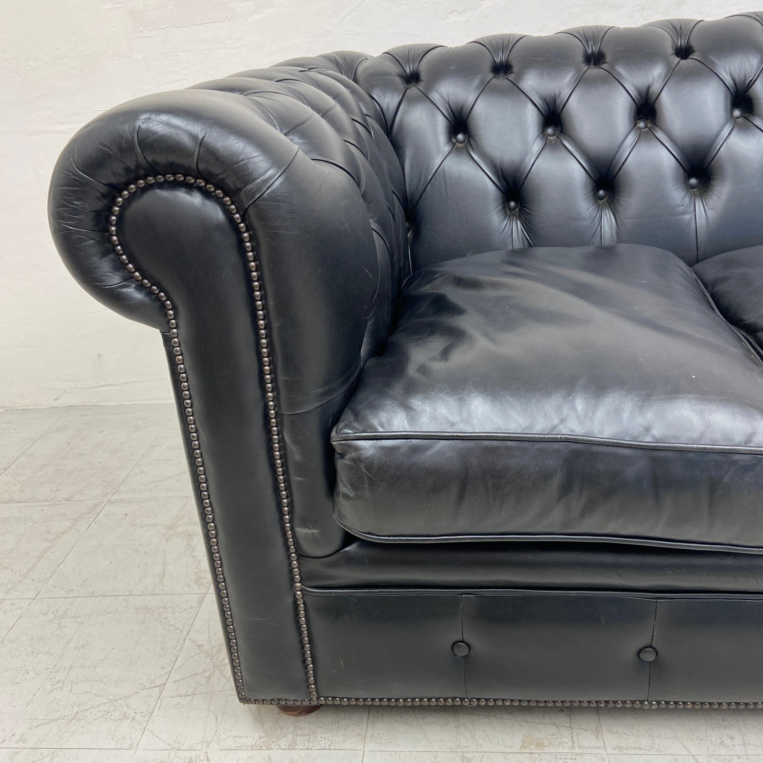 A black leather three seater Chesterfield sofa having a scrolled deep button back and arms over a - Image 4 of 4