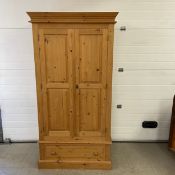 A 19th century style pine wardrobe with hanging space above a base section fitted with a drawer. H.
