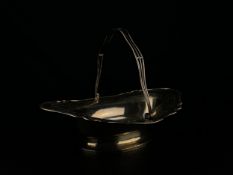 A hallmarked silver swing handled basket with pierced and engraved border on oval foot, Sheffield