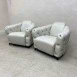 A pair of contemporary Italian white leather armchairs each having a curved back and deep buttoned