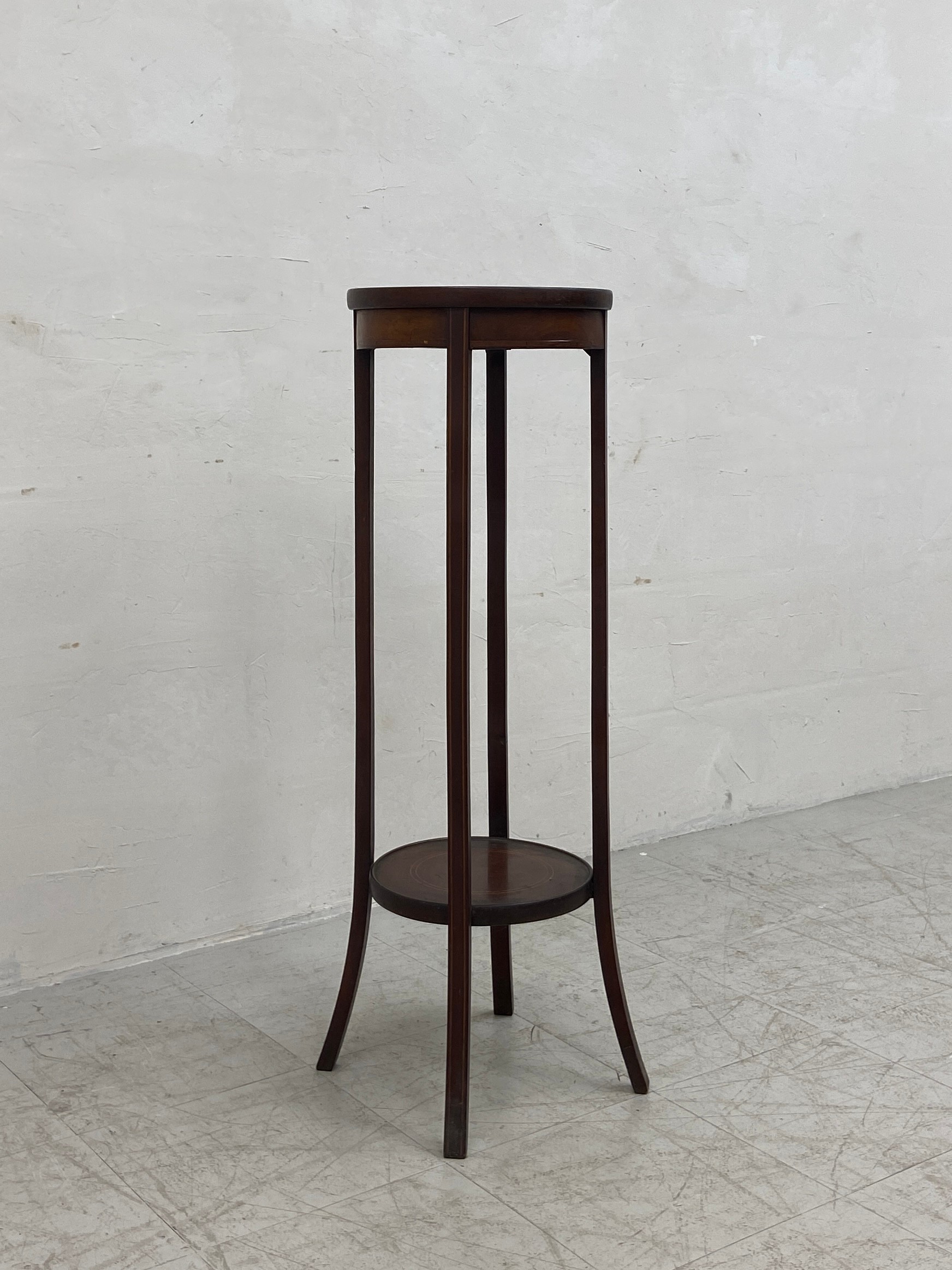 A C.1900 mahogany plant stand having a circular satinwood inlaid top raised on four flat splayed