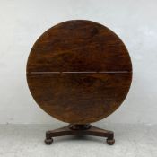 A William IV rosewood tilt top table dining table on triform acanthus carved base. H.73 Dia.128cm (