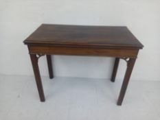 A Georgian mahogany card table having a rectangular fold-out top hinged to reveal a baize lined