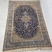 A large Persian style Sarouk carpet having a central diamond lozenge medallion surrounded by