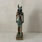 A 20th century carved stone and glazed statue depicting the ancient Egyptian deity Anubis. H.34cm (