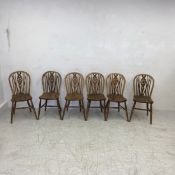 A set of six 19th century elm and beech wheelback dining chairs each having a spindled back over a