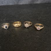 Four rings to include an 18k gold gypsy ring with a central 0.014 carat round diamond flanked by two