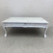 A painted coffee table in the 19th century style with opposing frieze drawers raised on carved