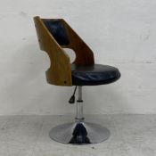 A mid century laminated ply and faux leather tub chair with adjustable height mechanism. H.85.5cm (