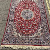 A large Persian style Sarouk carpet having a central diamond lozenge medallion surrounded by