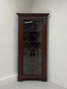 A late 19th century mahogany floor standing corner display cabinet having a dentil moulded cornice