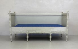 A 19th century painted Swedish Gustavian sofa with raised back and sides and carved detail on leaf