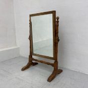A 19th century walnut dressing swing mirror having a rectangular plate in a crossbanded frame raised