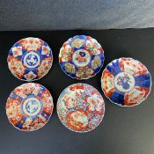 A collection of five 19th century and later Japanese Imari plates each hand decorated with panels of